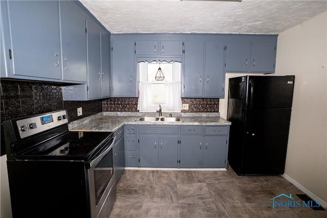 1702 E Hopkins St, Defiance, OH 43512 - kitchen with stainless steel electric range oven, freestanding refrigerator, a sink, backsplash, and a textured ceiling
