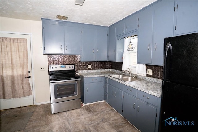 1702 E Hopkins St, Defiance, OH 43512 - kitchen with stainless steel range with electric cooktop, freestanding refrigerator, a sink, backsplash, and light countertops