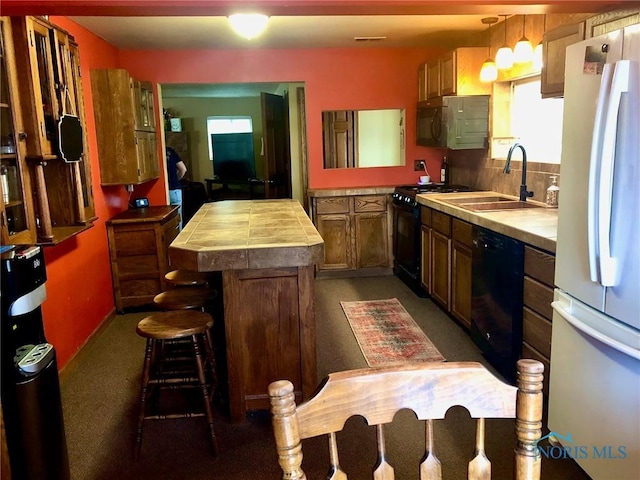 5151 Keller Rd, Walbridge, OH 43465 - kitchen with black appliances, a center island, carpet flooring, a sink, and a peninsula
