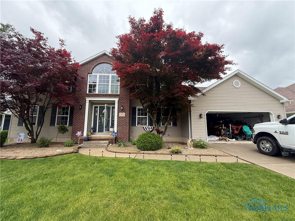 1506 Misty Oaks Dr, Findlay, OH 45840 - view of front of home featuring a garage, driveway, and a front yard