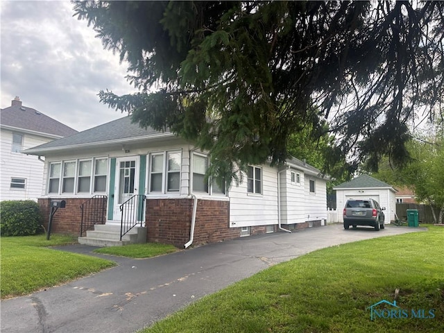 181 Osborne St, Rossford, OH 43460 - view of front facade featuring driveway, a front yard, brick siding, and a detached garage