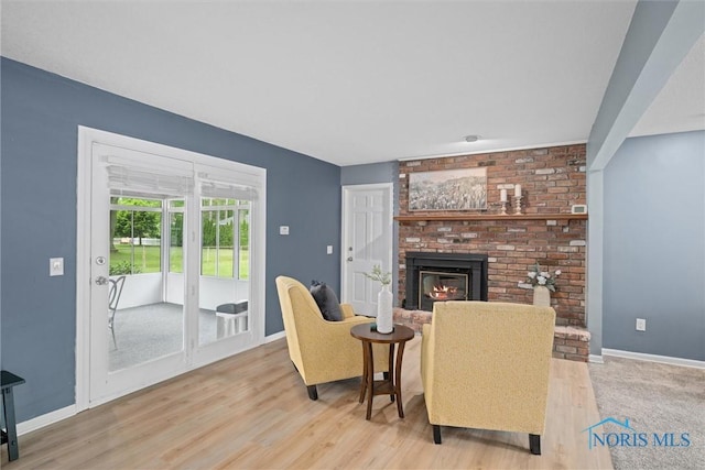 1956 Thornapple Dr, Toledo, OH 43614 - living area with light wood-type flooring, a brick fireplace, and baseboards