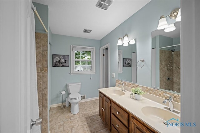 1956 Thornapple Dr, Toledo, OH 43614 - full bath with tiled shower, double vanity, toilet, baseboards, and tile patterned flooring