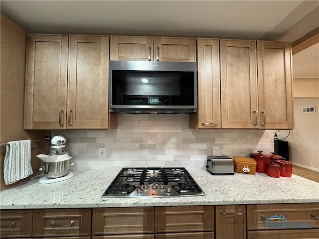 1226 Champe Rd, Toledo, OH 43615 - kitchen with stainless steel appliances, backsplash, light stone countertops, and baseboards