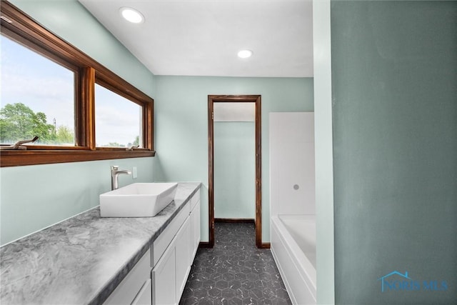 503 Church St, Helena, OH 43435 - full bathroom with vanity, a tub to relax in, recessed lighting, and baseboards