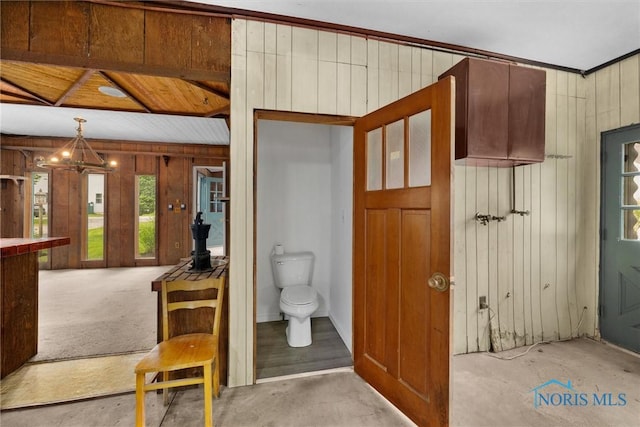 503 Church St, Helena, OH 43435 - bathroom with wood walls, toilet, and a chandelier