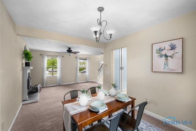 119 Mallard Rd, Perrysburg, OH 43551 - carpeted dining space featuring baseboards, ceiling fan, a fireplace with raised hearth, and a chandelier