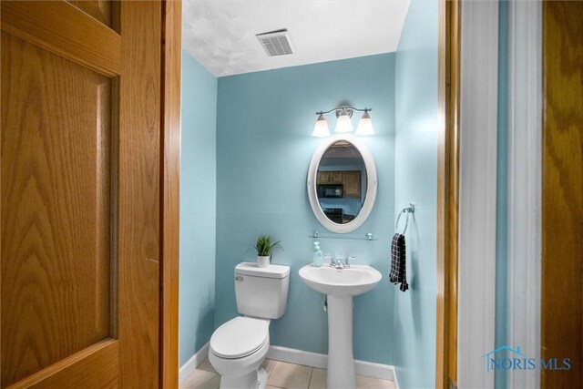 119 Mallard Rd, Perrysburg, OH 43551 - half bathroom featuring toilet, tile patterned flooring, a sink, and baseboards
