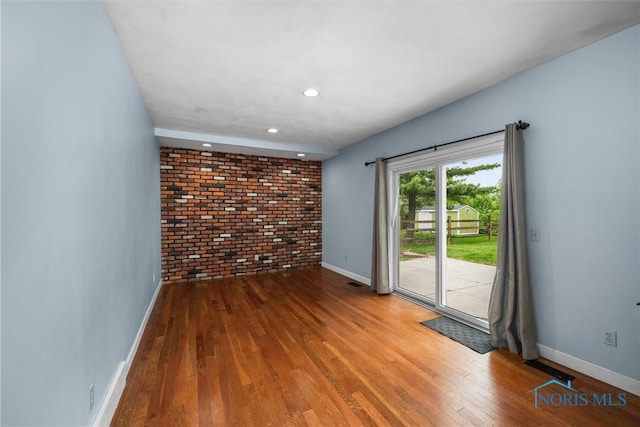 119 Mallard Rd, Perrysburg, OH 43551 - empty room featuring brick wall, baseboards, wood finished floors, and recessed lighting
