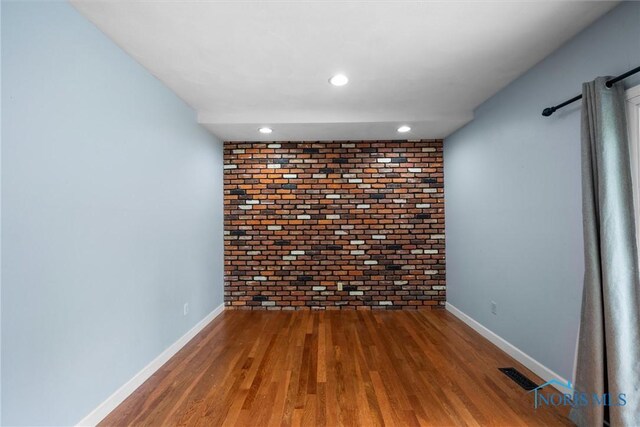 119 Mallard Rd, Perrysburg, OH 43551 - spare room featuring brick wall, wood finished floors, baseboards, and recessed lighting