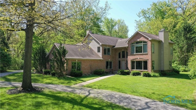 8801 W Bancroft St, Toledo, OH 43617 - view of front of home featuring a chimney, brick siding, and a front lawn