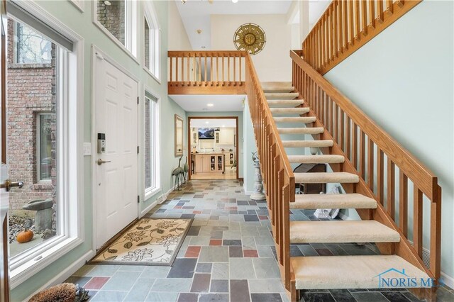 8801 W Bancroft St, Toledo, OH 43617 - foyer with a towering ceiling, stairs, stone tile floors, and baseboards