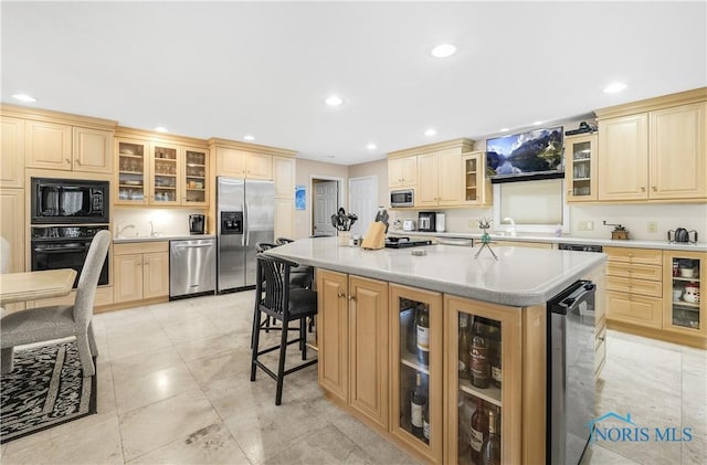 8801 W Bancroft St, Toledo, OH 43617 - kitchen with black appliances, a center island, beverage cooler, recessed lighting, and light countertops