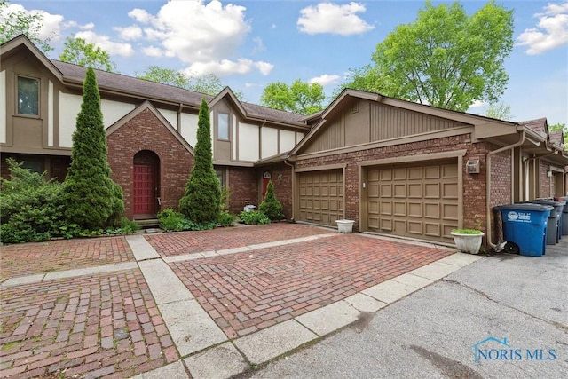 1250 Hidden Ridge Rd, Toledo, OH 43615 - view of front facade with brick siding, decorative driveway, a garage, and stucco siding
