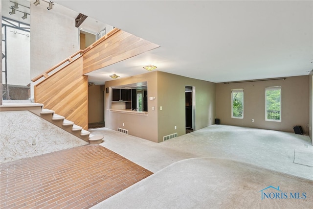 1250 Hidden Ridge Rd, Toledo, OH 43615 - unfurnished living room featuring stairway and carpet flooring