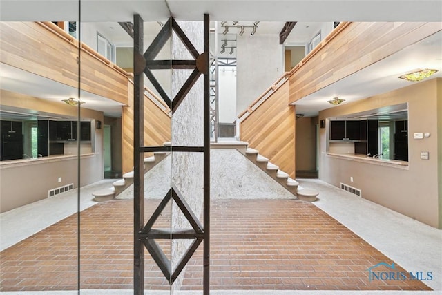 1250 Hidden Ridge Rd, Toledo, OH 43615 - staircase with a high ceiling and brick floors