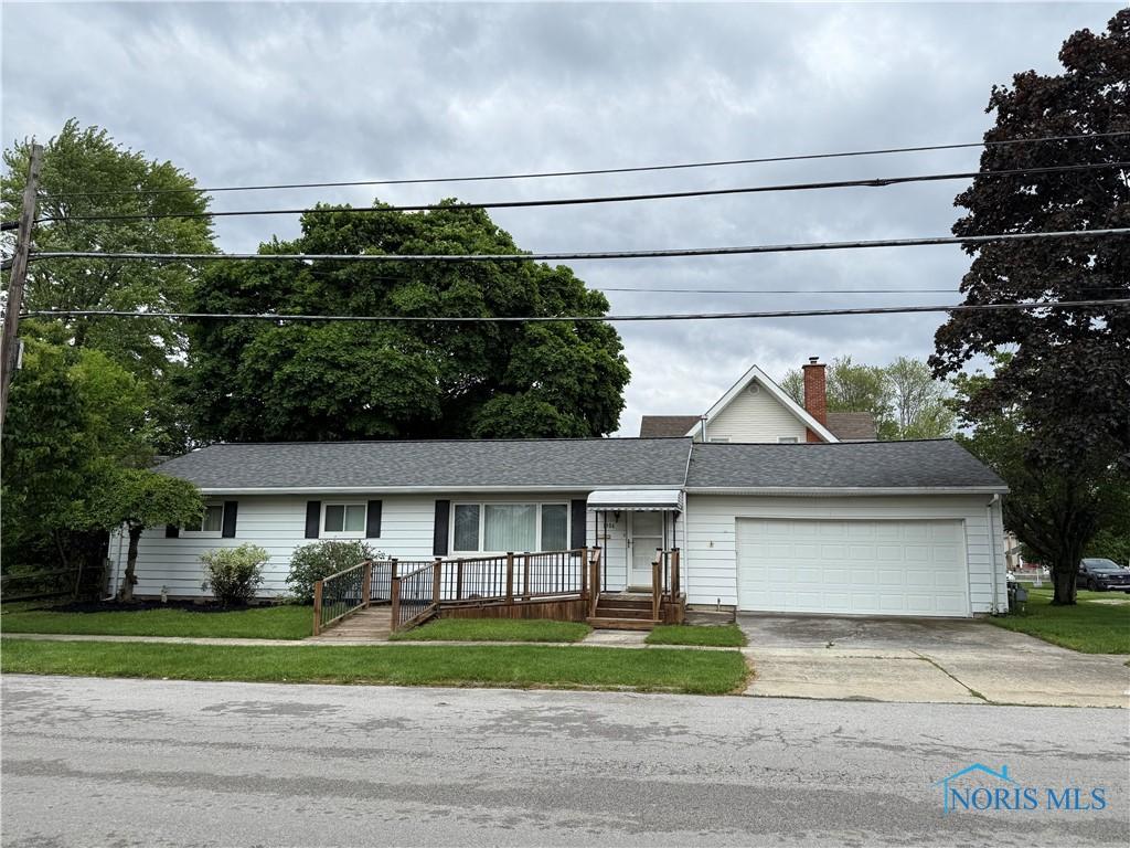1306 N Union St, Fostoria, OH 44830 - ranch-style house with a garage, concrete driveway, a front yard, and a chimney