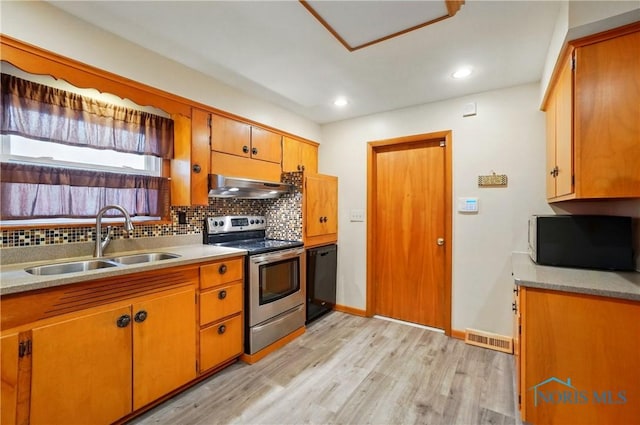 1306 N Union St, Fostoria, OH 44830 - kitchen featuring stainless steel electric range oven, under cabinet range hood, a sink, backsplash, and light wood-style floors