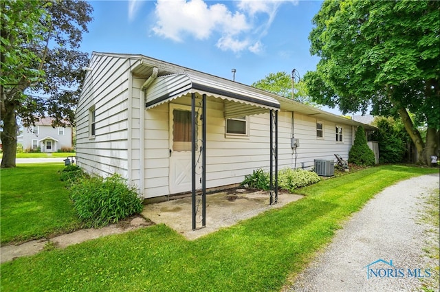 1306 N Union St, Fostoria, OH 44830 - view of side of home featuring a lawn and central air condition unit