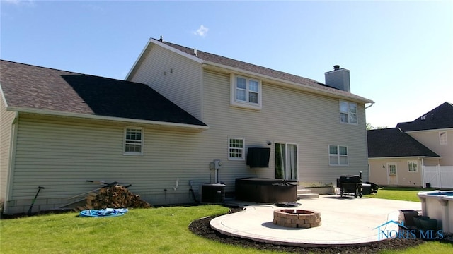 640 Hemlock St, Wauseon, OH 43567 - back of property featuring a hot tub, a patio, a chimney, and a fire pit