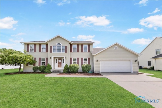 640 Hemlock St, Wauseon, OH 43567 - colonial-style house featuring a garage, concrete driveway, and a front yard