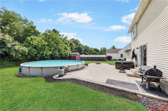 640 Hemlock St, Wauseon, OH 43567 - swimming pool featuring a hot tub, a storage unit, a patio area, and a fenced backyard