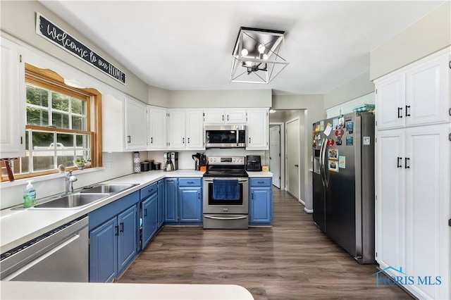 640 Hemlock St, Wauseon, OH 43567 - kitchen with stainless steel appliances, blue cabinetry, white cabinets, light countertops, and dark wood-style flooring
