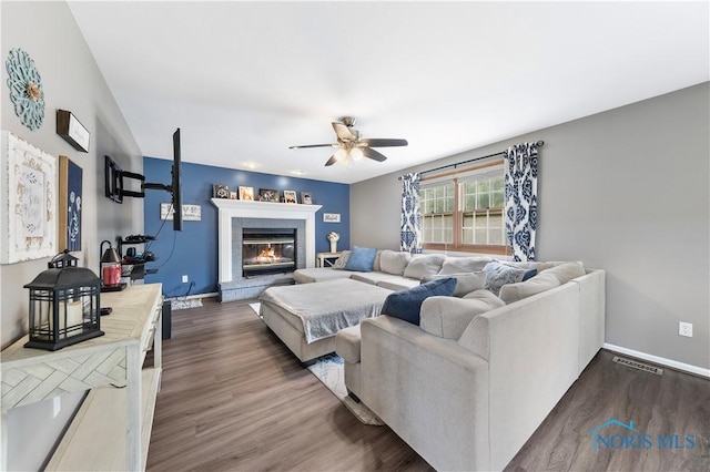 640 Hemlock St, Wauseon, OH 43567 - living room featuring ceiling fan, a glass covered fireplace, and dark wood-style floors