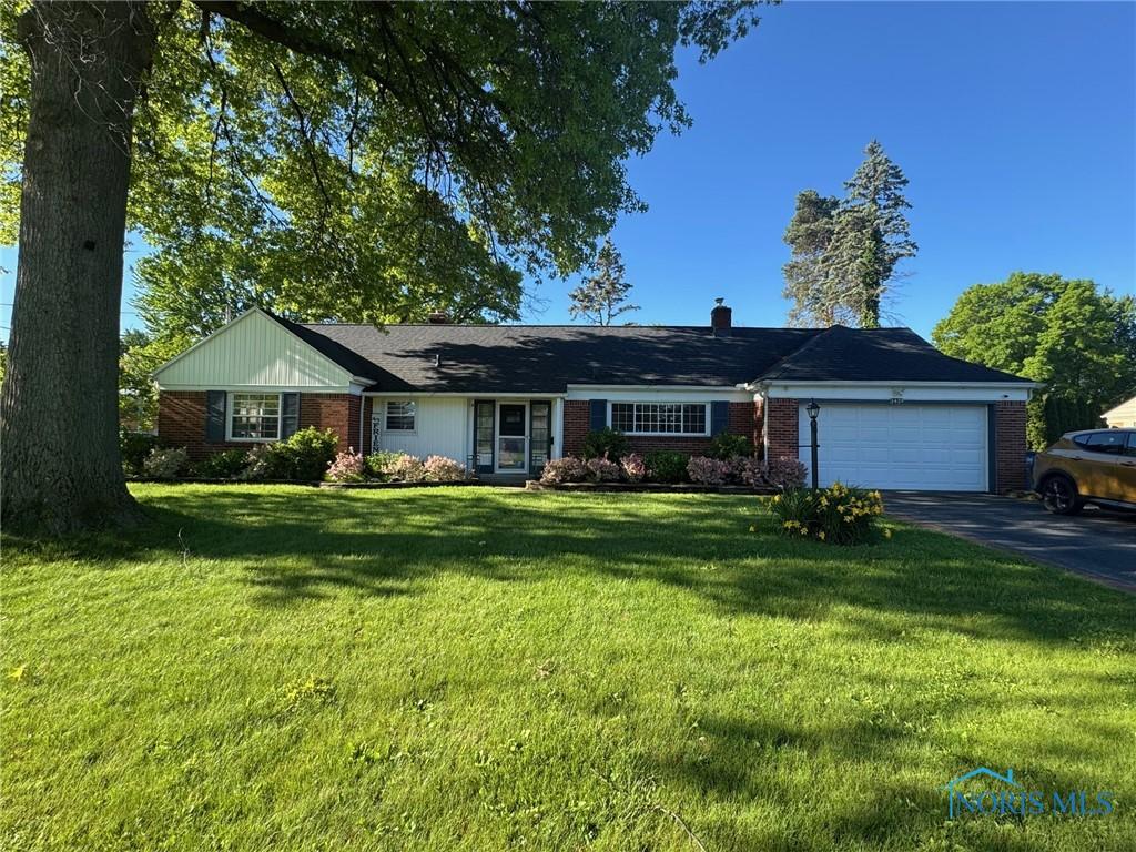3419 Christie Blvd, Toledo, OH 43606 - single story home with driveway, an attached garage, brick siding, and a front yard