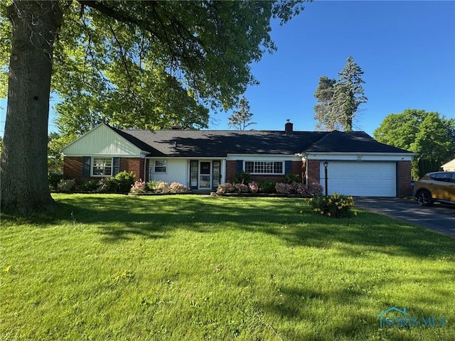 3419 Christie Blvd, Toledo, OH 43606 - single story home with driveway, an attached garage, brick siding, and a front yard