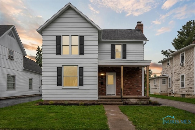 143 Laquineo St, Findlay, OH 45840 - view of front facade with a chimney, a front lawn, a shingled roof, a porch, and brick siding