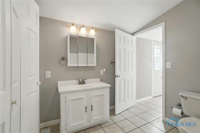 404 W Yates Ave, Findlay, OH 45840 - bathroom featuring toilet, vanity, tile patterned flooring, vaulted ceiling, and baseboards
