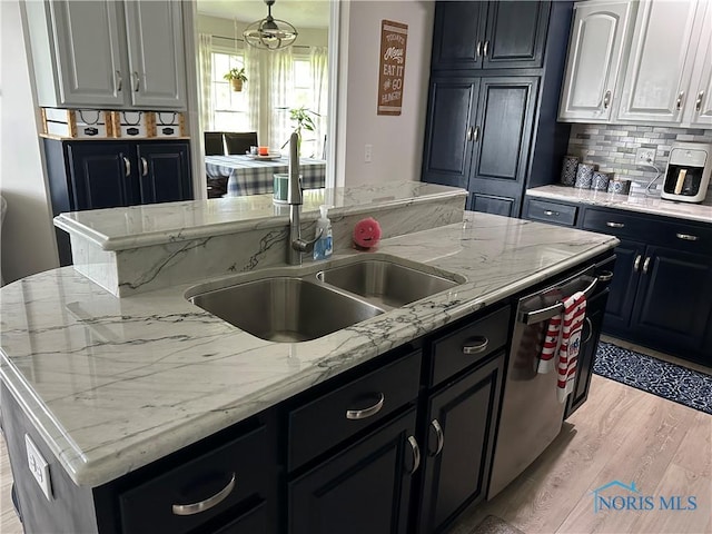 20515 Lockwood Rd, Defiance, OH 43512 - kitchen featuring a sink, stainless steel dishwasher, light wood-style flooring, decorative backsplash, and light stone countertops