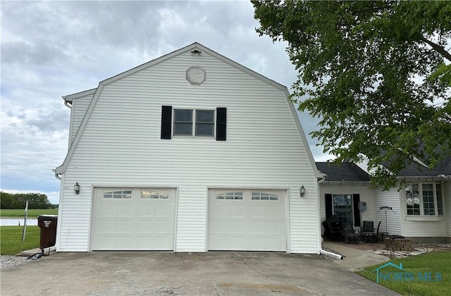 20515 Lockwood Rd, Defiance, OH 43512 - view of side of home featuring a garage, concrete driveway, and a gambrel roof