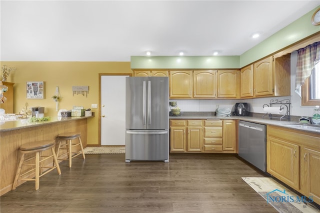 9389 County Road N2, Napoleon, OH 43535 - kitchen featuring appliances with stainless steel finishes, dark wood finished floors, a kitchen bar, a sink, and light brown cabinets