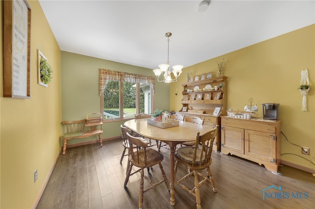 9389 County Road N2, Napoleon, OH 43535 - dining area featuring a chandelier, wood finished floors, and baseboards