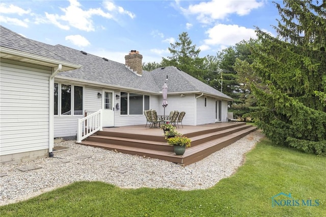 9389 County Road N2, Napoleon, OH 43535 - rear view of house featuring a deck, a chimney, a shingled roof, and a lawn