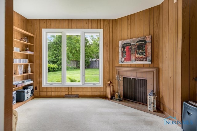 4123 Shamley Green Dr, Toledo, OH 43623 - unfurnished living room featuring wooden walls, plenty of natural light, carpet, built in features, and a fireplace