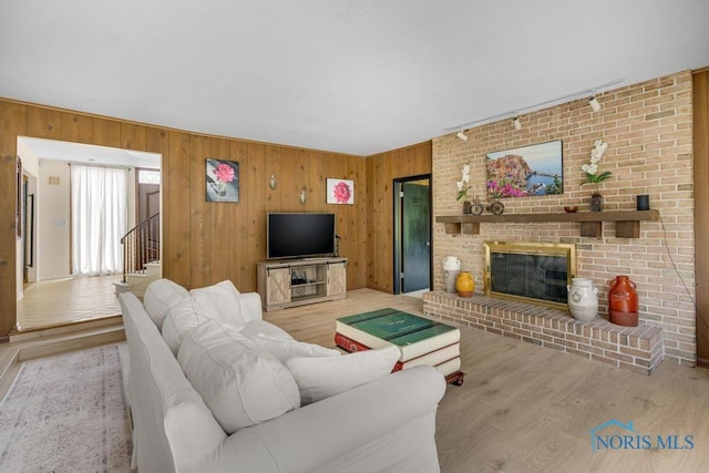 4123 Shamley Green Dr, Toledo, OH 43623 - living area featuring wood finished floors, a fireplace, wood walls, and stairs