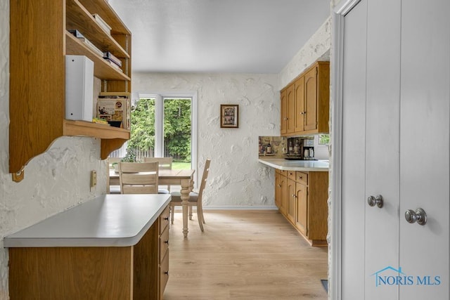 4123 Shamley Green Dr, Toledo, OH 43623 - kitchen with light wood finished floors, baseboards, light countertops, a textured wall, and brown cabinetry