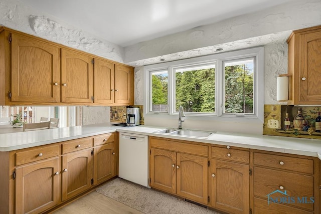 4123 Shamley Green Dr, Toledo, OH 43623 - kitchen featuring dishwasher, a sink, light countertops, brown cabinetry, and tasteful backsplash