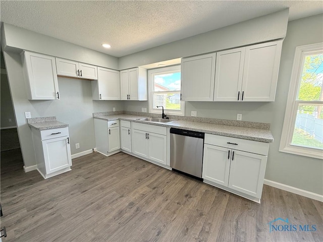 2655 101st St, Toledo, OH 43611 - kitchen featuring dishwasher, a sink, white cabinetry, wood finished floors, and a textured ceiling