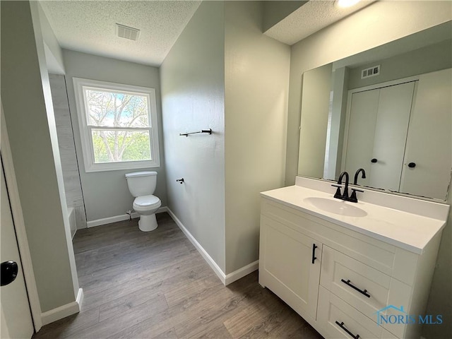 2655 101st St, Toledo, OH 43611 - full bath featuring a textured ceiling, toilet, vanity, wood finished floors, and baseboards
