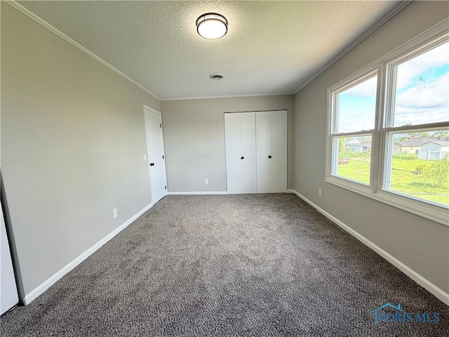 2655 101st St, Toledo, OH 43611 - unfurnished bedroom featuring a textured ceiling, ornamental molding, carpet floors, baseboards, and a closet