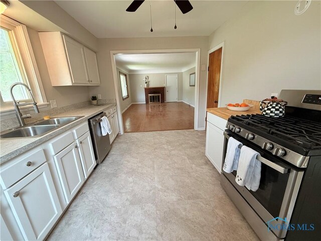 1641 Morrison Rd, Fremont, OH 43420 - kitchen featuring appliances with stainless steel finishes, a sink, light countertops, ceiling fan, and white cabinets