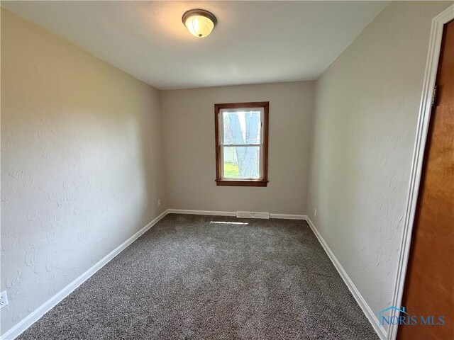 1641 Morrison Rd, Fremont, OH 43420 - unfurnished room featuring dark colored carpet, baseboards, and a textured wall