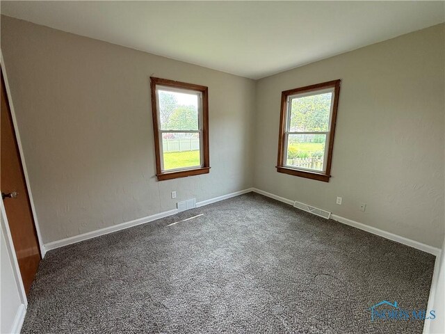 1641 Morrison Rd, Fremont, OH 43420 - empty room with healthy amount of natural light, dark colored carpet, and baseboards