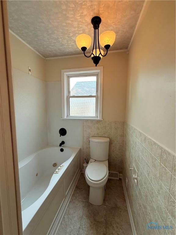 1641 Morrison Rd, Fremont, OH 43420 - bathroom with a tub with jets, toilet, tile walls, ornamental molding, and tile patterned floors