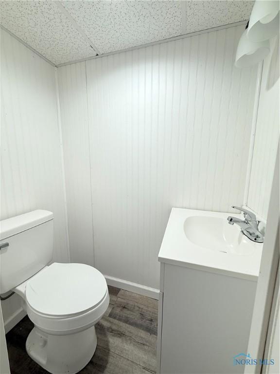 1641 Morrison Rd, Fremont, OH 43420 - half bath featuring a drop ceiling, vanity, toilet, and wood finished floors