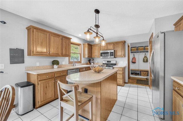 8225 Hidden Forest Dr, Holland, OH 43528 - kitchen with appliances with stainless steel finishes, light countertops, a kitchen island, and light tile patterned floors